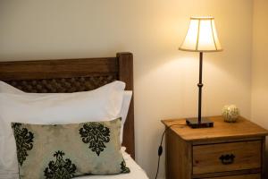 a lamp on a night stand next to a bed at Sete Cidades Quinta Da Queiró in Sete Cidades