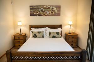 a bedroom with a large bed with two night stands at Sete Cidades Quinta Da Queiró in Sete Cidades