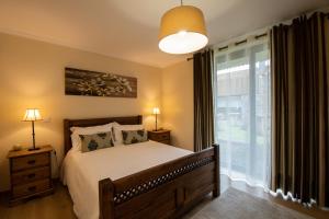 a bedroom with a bed and a large window at Sete Cidades Quinta Da Queiró in Sete Cidades