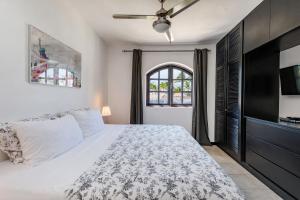 a bedroom with a large bed and a tv at Flor del Mar Condo Punta Cana Beachfront in Punta Cana +145 photos