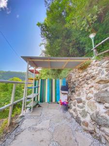 ein Tor zu einer Steinmauer mit einem Schutzraum in der Unterkunft La casa con giardino tra borghi, boschi cascate e natura in Borzonasca