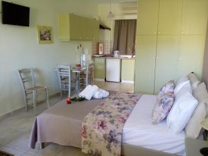 a bedroom with a bed and a kitchen with a table at ARETI APARTMENTS in Petalidi