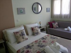 a small bedroom with a bed and a couch at ARETI APARTMENTS in Petalidi
