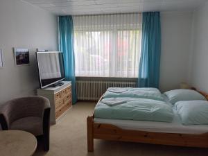 a bedroom with a bed and a tv and a window at Privatzimmer Sutanto in Reppenstedt