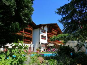 a building with a pool in front of it at Hotel Restaurant Knobelboden in Oberterzen