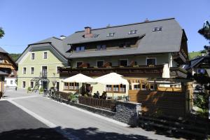 restauracja z parasolami przed budynkiem w obiekcie Gasthof Hotel Andlwirt w mieście Sankt Andrä im Lungau