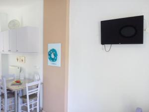 a room with a tv on a wall with a table at ARETI APARTMENTS in Petalidi