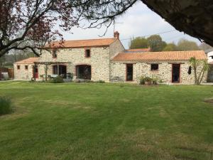 una antigua casa de piedra con un gran patio en Au Mas Retz De Jade, en Chauvé