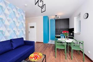 een woonkamer met een blauwe bank en een tafel bij Sleep Well Inżynierska in Wrocław