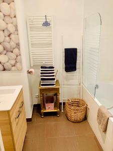 a bathroom with a shower and a basket of towels at Appartment Le Charme du Bourgeois in Nice