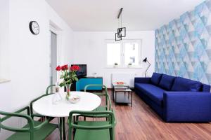 a living room with a blue couch and a table at Sleep Well Inżynierska in Wrocław