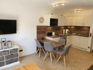 a kitchen with a table and chairs and a television at Fischerweg 5 in Norddeich