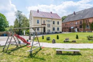 un parque infantil en un patio con un edificio en Landpension-Kleeblatt, en Würchwitz