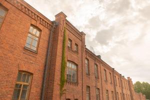 un bâtiment en brique avec du lierre sur son côté dans l'établissement Hotelli Rakuuna, à Lappeenranta