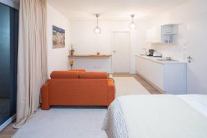 een woonkamer met een oranje bank en een keuken bij Apartment Vroni in Salzburg