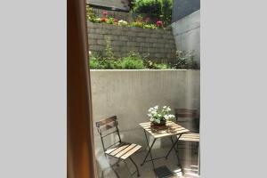 een patio met een tafel, een stoel en bloemen bij Apartment Vroni in Salzburg