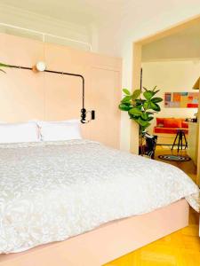 ein Schlafzimmer mit einem großen weißen Bett mit einer Pflanze in der Unterkunft Downtown Boutique Apartment in Thessaloniki