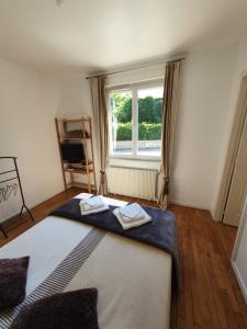 a bedroom with a large bed with two towels on it at Santa Maria in Saint-Ouen-de-Mimbré