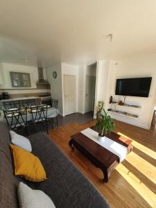 a living room with a couch and a table at Santa Maria in Saint-Ouen-de-Mimbré