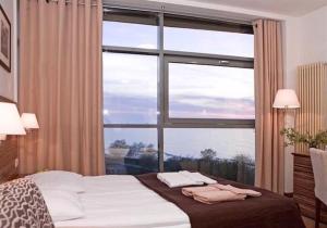 科沃布热格ARKA APARTAMENT DELUXE 723b的有大窗户的房间里的一张床 更多36张照片