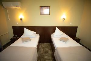 two beds in a hotel room with books on them at Hotel Select Slobozia in Slobozia