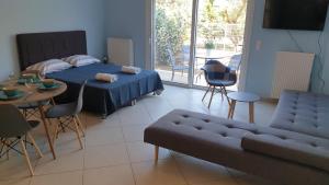 sypialnia z łóżkiem, stołem i kanapą w obiekcie Eretria Apartments FM14 w Erétrii