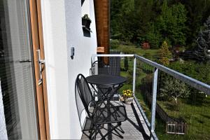 una silla negra sentada en el balcón de una casa en Apartmá Jablonec, en Jablonec nad Nisou