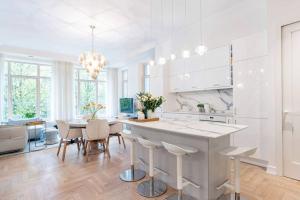 a white kitchen with a table and a dining room at Jogailos Residence peaceful Old Town luxury 3 bdr, 2 bthr, FREE GARAGE, top-speed WIFI in Vilnius
