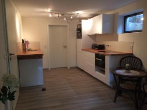 a kitchen with white cabinets and a table in a room at Ferienwohnung am Mozarthügel in Warstein