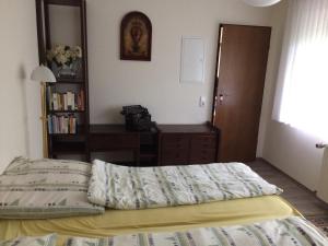 a bedroom with a bed and a desk and a book shelf at Ferienwohnung am Mozarthügel in Warstein