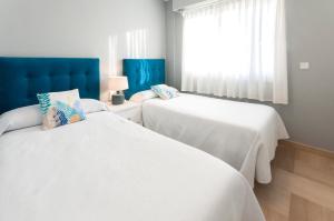 ガンディアにあるAG Turquesa Premiumの窓付きの客室で、白いベッド2台が備わります。