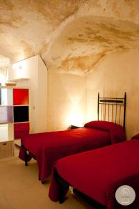 una camera con 2 letti rossi di Da Zia Lalla a Matera