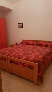 una camera con letto e piumone rosso di ANFORA Rosso a Canneto