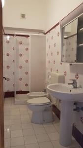 bagno con servizi igienici, lavandino e specchio di ANFORA Rosso a Canneto