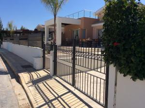 a metal fence in front of a house at Dream House Latchi Villa in Polis Chrysochous
