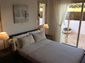 Un dormitorio con una cama y una puerta corrediza de vidrio. en Dream House Latchi Villa, en Polis Chrysochous 60 fotos más
