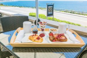 un vassoio di prodotti per la colazione su un tavolo con vista sull'oceano di Inn on the Sound a Falmouth