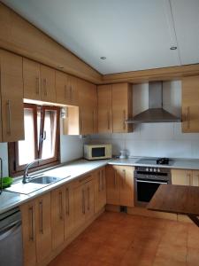 una cucina con mobili in legno, un lavello e una stufa di Casa las Niñas a Quintanaedo