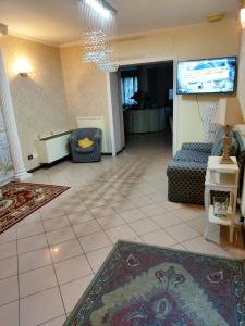 a living room with a couch and a tv at Hotel La Torre in Rimini