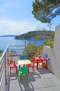 einen Tisch und Stühle auf einem Balkon mit Blick auf das Wasser in der Unterkunft Villa Stina Drvenik in Drvenik