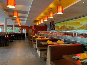 Un restaurante con mesas y sillas y un bar. en Da Yang, en Rankweil