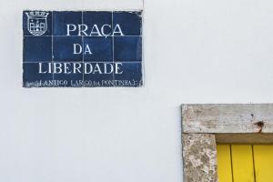 ein Schild an der Seite eines Gebäudes mit gelber Tür in der Unterkunft Lemon Tree Stay in Faro