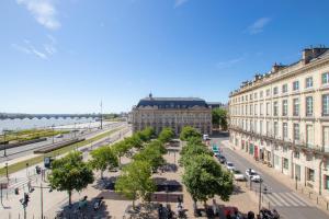 eine Straße in einer Stadt mit Gebäuden und Bäumen in der Unterkunft Appartement Luxe avec Climatisation Parking Vue Exeptionnelle in Bordeaux