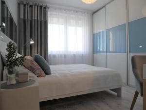 una camera con un letto bianco e una finestra di Apartament NA KLIFIE a Słupsk