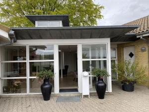 a conservatory with two large black vases at Hotel Sov Godt Herning in Herning