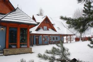 una casa con la neve sul tetto di Pokoje i Apartamenty u Architekta a Czarna Góra