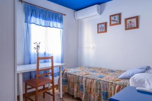 a bedroom with a bed and a desk and a chair at Casa de Chocolate in Martos