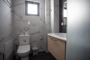 a bathroom with a toilet and a sink at Gold Apartments in Platanes