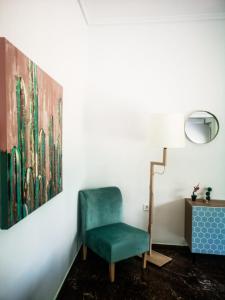 a green chair in a room with a painting at Explore Greece from Colorful City Centre Apartment in Chalkida