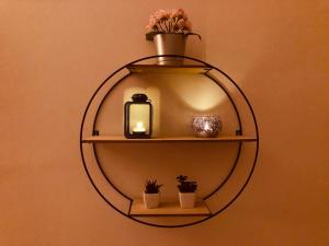 a round shelf with a candle and plants on a wall at The Student's Home in Kavála